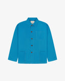 Front flat shot of bright blue, buttoned organic cotton overshirt. Clear view of chest and hip pockets, corozo buttons and Uskees branding label.