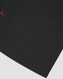 Closer view of mid section of charcoal-grey, buttoned organic cotton overshirt from Uskees. Focus on hem, pockets and corozo buttons.