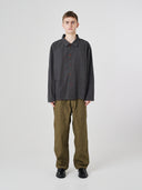 Full-length view of man wearing an Uskees charcoal-grey cotton overshirt paired with khaki-green pants.
