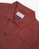 Close-up top-half view of #3001 chestnut-brown organic cotton drill overshirt. With focus on collar, Uskees brand label and corozo buttons.
