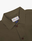 Close-up view of 3001 dark taupe, buttoned organic cotton overshirt from Uskees showing corozo buttons, brand label, collar and hanging hoop.