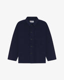 Front flat shot of deep indigo, buttoned corduroy overshirt. Clear view of corozo buttons, 3 pockets and Uskees branding label.