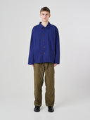 Full-length view of man wearing an Uskees deep indigo cotton overshirt paired with khaki pants.