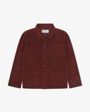Front flat shot of deep wine berry, buttoned corduroy overshirt. Clear view of corozo buttons, 3 pockets and Uskees branding label.