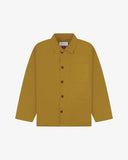 Front flat shot of mustard-yellow, buttoned organic cotton overshirt. Clear view of chest and hip pockets, corozo buttons and simple, boxy shape.
