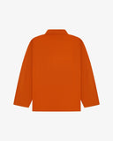 Back view of golden-orange, buttoned organic cotton overshirt with view of reinforced elbow area and boxy silhouette.