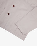 View of the hem, sleeve and hip pocket of the 3001 Uskees button-down organic cotton overshirt in lunar stone (light grey).
