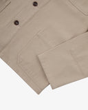 View of the hem, sleeve and hip pocket of the 3001 Uskees button-down drill overshirt in oatmeal (beige).