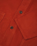 Closer view of mid section of rust-red, buttoned corduroy overshirt from Uskees. Focus on cuff, pockets, corozo buttons and corduroy texture.