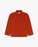 Front flat shot of rust-red, buttoned corduroy overshirt. Clear view of chest and hip pockets, corozo buttons and Uskees branding label.