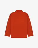 Back view of rust-red, buttoned organic cotton overshirt with view of reinforced elbow area and boxy silhouette.