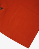 Closer view bottom-right section of rust-red, buttoned organic cotton overshirt from Uskees. Focus on hip pocket and corozo buttons.