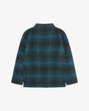 Back view of peacock blue check, buttoned Pennine wool overshirt with view of reinforced elbow area and boxy silhouette.