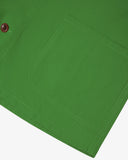 Closer view of bright green, buttoned organic cotton overshirt from Uskees. Focus on hem, placket, hip pocket and corozo buttons.
