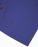 Closer view of mid section of ultra blue, buttoned organic cotton overshirt from Uskees. Focus on hem, pockets and corozo buttons.