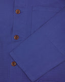 Closer view of mid section of ultra blue, buttoned organic cotton overshirt from Uskees. Focus on cuff, pockets and corozo buttons.