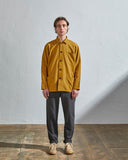 Full-length front view of model wearing #3001, yellow organic cotton overshirt paired with dark Uskees pants.