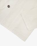 Close up view of an Uskees cream shirt jacket for men showing the pocket, cuff and Corozo button.