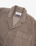Angled top-half view of #3006, beech (pale brown) organic corduroy blazer. With focus on collar, notch lapels, breast pocket, Uskees brand label and corozo buttons.