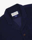 Close-up front view of organic cord deep indigo blazer showing the collar, lapels and Uskees brand label.