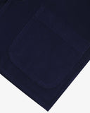 Close-up view of hem, hip patch pocket and texture of 11 wale organic corduroy, deep indigo blazer from Uskees.