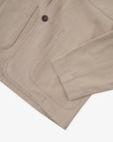 Closer detail view of hip patch pocket, hemline and the extra durable weave of the organic cotton oatmeal (beige) drill fabric.