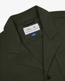 Close-up top-half view of #3006, vine green organic cotton-drill blazer. With focus on collar, lapels, Uskees brand label and corozo buttons.