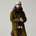 Male model wearing an Uskees corduroy suit in woodland green and a signature baseball cap.