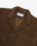 Close up view of an Uskees brown corduroy blazer for men with a visible brand label on a white background.