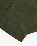 Close up view of Uskees dark green men's cord jacket showing pockets and cuff detail.