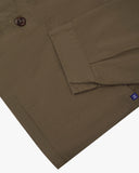 Close-up view of one of two hip pockets, cuff and Uskees branding tag of the 3041 signal jacket. Also is a closer view of the herringbone texture of the dark taupe cotton. 