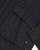 Close up view of Uskees black ripstop field jacket with focus on a zip and gusseted chest pocket , cuff and small branding tab.