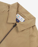 Close up view of Uskees khaki ripstop field jacket with focus on the collar, zipper, hanging hook and branding label.