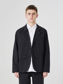Three-quarter pose of man wearing the Uskees 3047 Docklands black blazer, paired with white shirt.