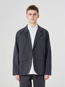 Three-quarter pose of man wearing the Uskees 3047 Docklands charcoal-grey blazer, paired with white shirt.