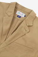 Close-up and angled front view of the 3047 docklands blazer showing the twill fabric texture, collar, lapel, Uskees branding label and jetted breast pocket.