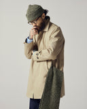 Male model wearing a beige Uskees 3048 car coat and green knit beanie.