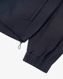 Close up view of Uskees midnight blue Evo shell coat with focus on cuff, waist toggle and welt pocket.