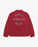 Back view flat shot of Uskees clay red coach jacket for men with focus on the the North Born Uskees slogan, straight-cut hem and elasticated cuffs.