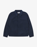 Front flat shot of Uskees navy blue coach jacket for men showing sharp, contemporary detailing including slanted welt pockets, cinch hem and popper fastening.