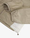 Close up of an Uskees zip up trekking jacket for men in light green/brown with showing the white side panel detail and the storage pouch.
