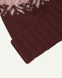 Close-up of the dusty pink snowflake hat from Uskees, clearly showing the ribbing of the adjustable cuff and texture of the natural Scottish lambswool.