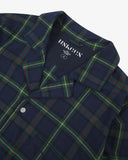 Close up shot of Uskees men's blue/green plaid pyjama top with focus on collar and Uskees brand label.