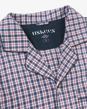 Close up shot of Uskees men's navy/berry plaid pyjama top with focus on collar and Uskees brand label.