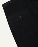 Close-up reverse view of Uskees midnight blue corduroy work pants with focus on left rear flap pocket, belt loops and adjustable button waist.