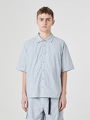 Top-half view of a male model wearing an Uskees pale blue-grey short-sleeve button front trek shirt.