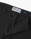 Close-up front view of the organic twill black 'commuter' trousers showing belt loops, zip fly, branding label and Corozo button.