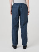 Back view of model wearing 5020 drill utility pants in blueberry. Indicating relaxed fit, two jetted pockets and length falling just above the ankle.
