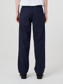 Close-up back view modelling 5021 Uskees men's organic twill midnight blue painter pants highlighting back patch pockets and gradual, narrowing leg.
