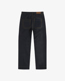 Full-length back view of raw orta denim workwear pants in dark indigo. Showing back pockets and tapered leg.